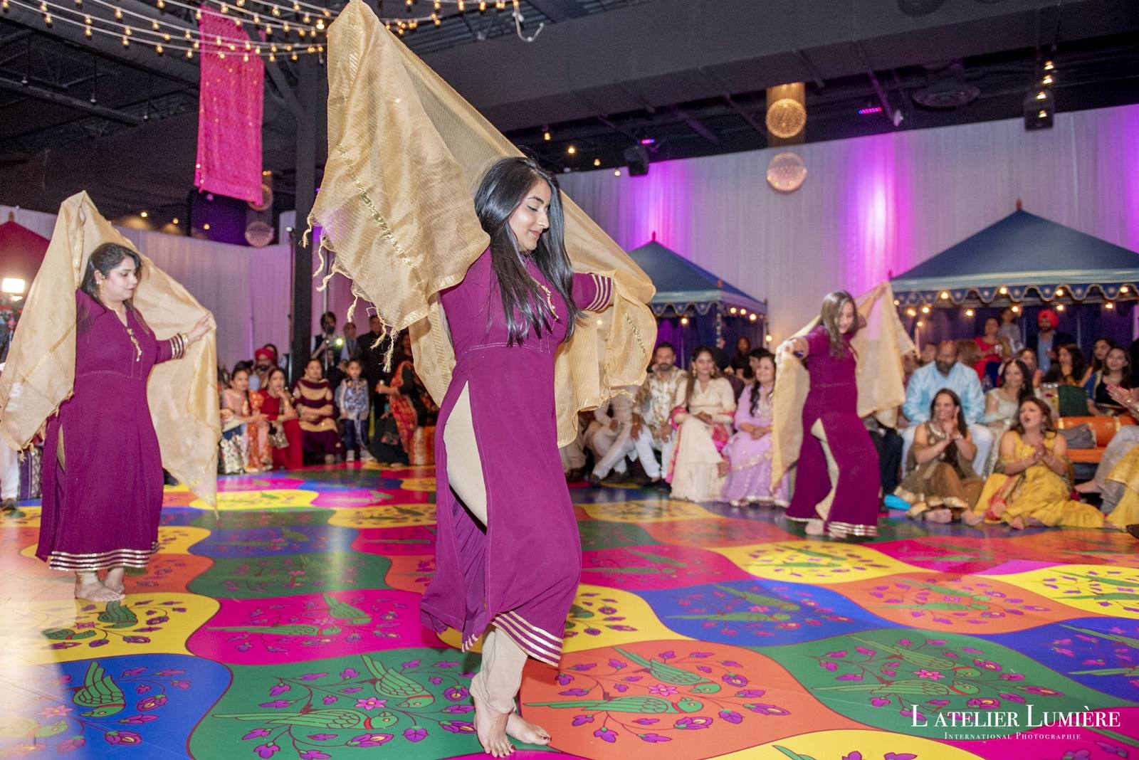 Guests dancing on a colourful custom printed floor at a sangeet