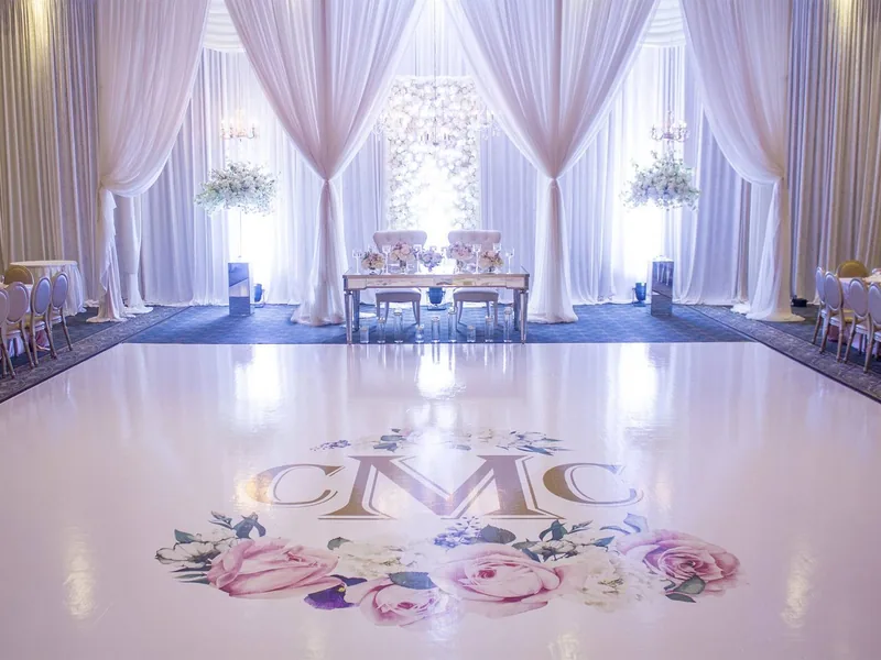 Custom printed monogram dance floor installed in a draped ballroom